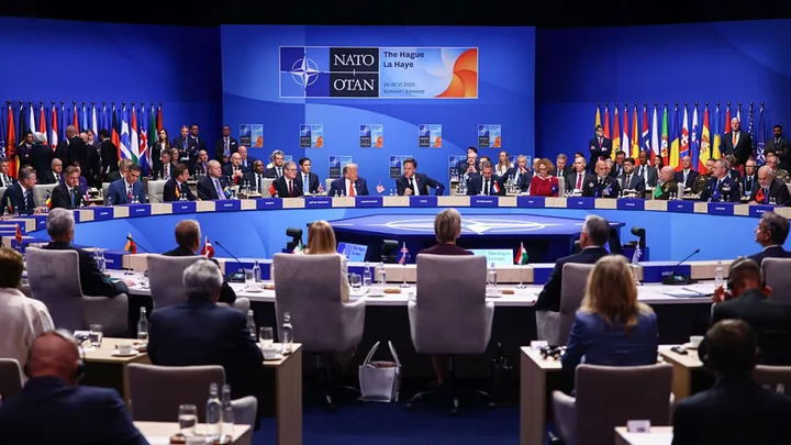 Reuniune NATO cu reprezentanți din diverse țări, discutând despre finanțarea apărării.