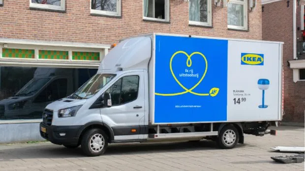 TIR IKEA parcat în fața unui magazin, cu reclame colorate pe lateral.