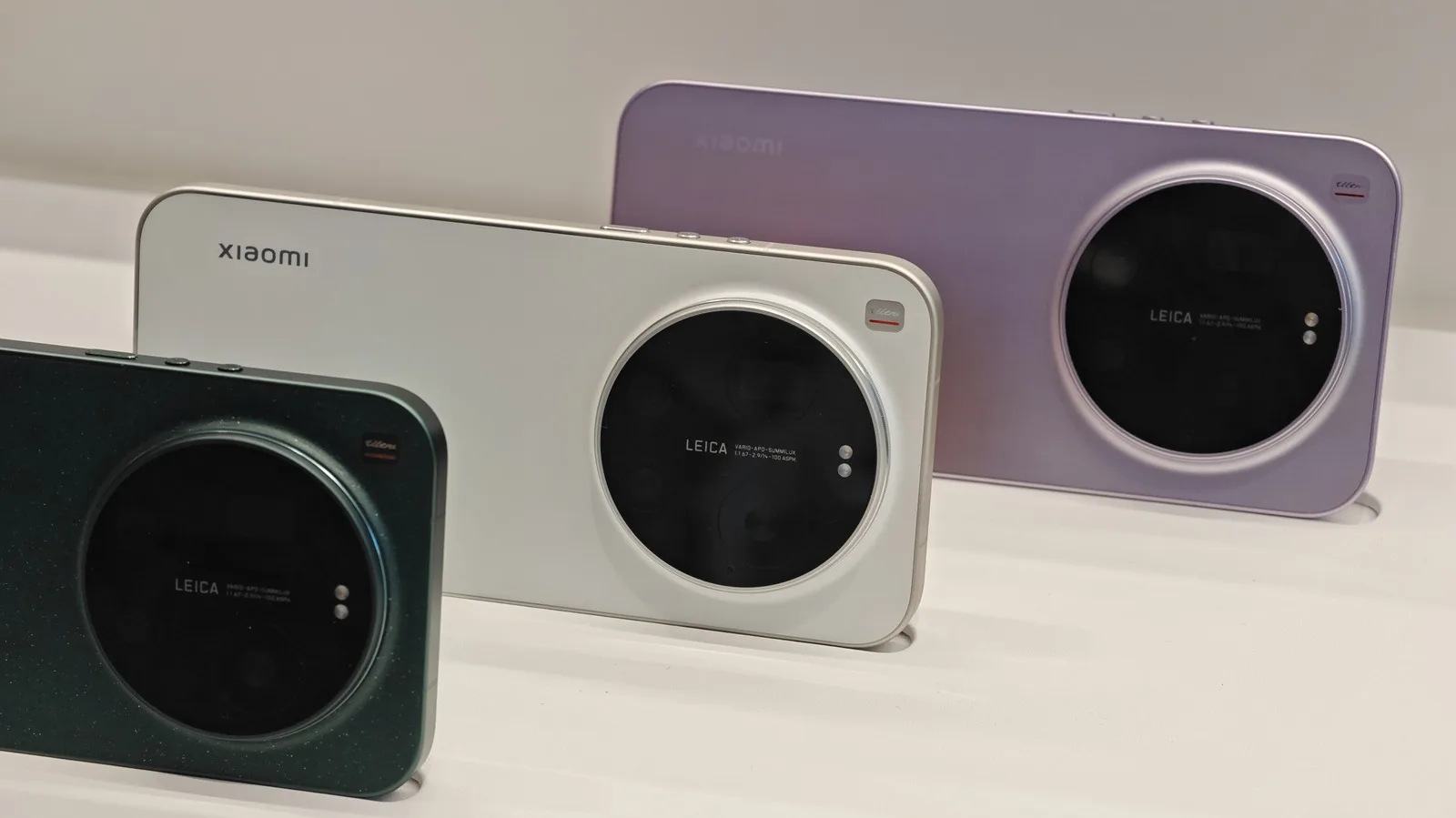 Telefoane inteligente expuse pe un stand, cu design modern și culori variate.