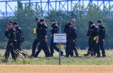 Grup de polițiști în apropierea aeroportului Leipzig/Halle, în contextul unei anchete de securitate.