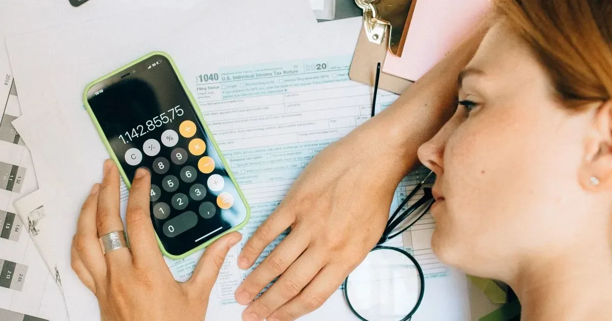 Calculatoare și documente pe birou, reflectând discrepanțe salariale.