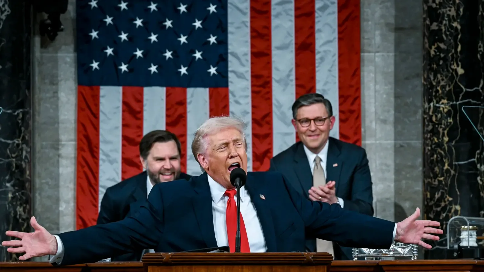 Donald Trump vorbește în fața Congresului, cu steagul în fundal.