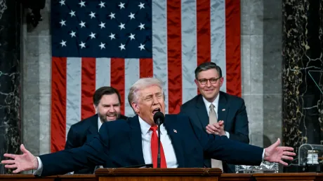 Donald Trump vorbește în fața Congresului, cu steagul în fundal.