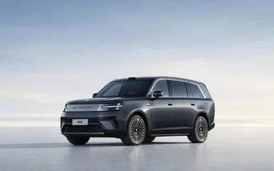 Mașină electrică modernă cu design elegant și roți mari, pe fundal deschis.