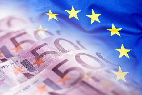 Bancnote euro și stelele Uniunii Europene pe fundal.