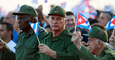 Protestatari cubanezi cu steaguri, în fața unei adunări publice.