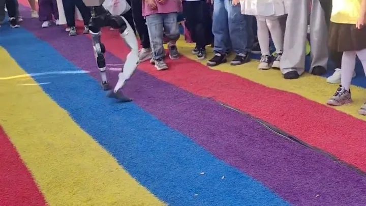 Un robot umanoid interacționează cu publicul într-un parc din China.