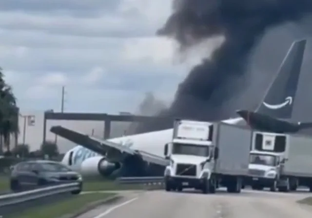 Avion cargo imobilizat pe pista aeroportului, cu fum ieșind din motor.