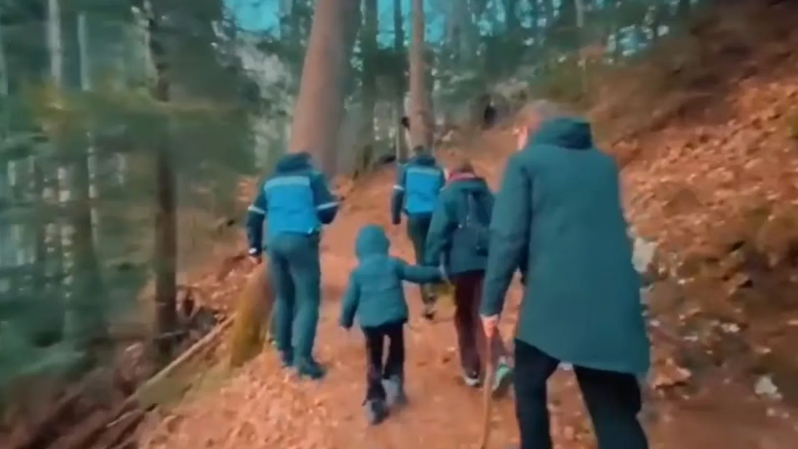 Turiști pe un traseu montan, admirând natura și ignorând avertizările de siguranță.