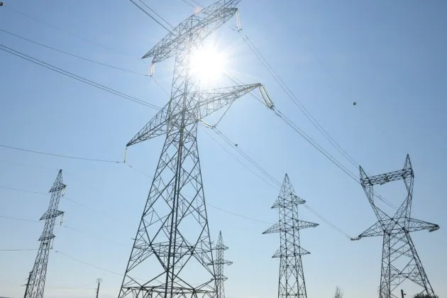 Turnuri de electricitate sub soarele strălucitor, simbolizând exporturile Ucrainei.