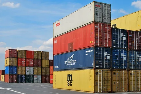 Containere colorate stivuite într-un port, simbolizând comerțul internațional.
