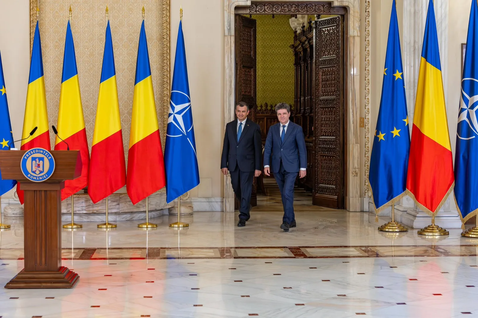 Eugen Tomac și Kelemen Hunor la consultări politice în fața drapelului României și Uniunii Europene.