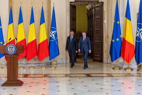 Eugen Tomac și Kelemen Hunor la consultări politice în fața drapelului României și Uniunii Europene.