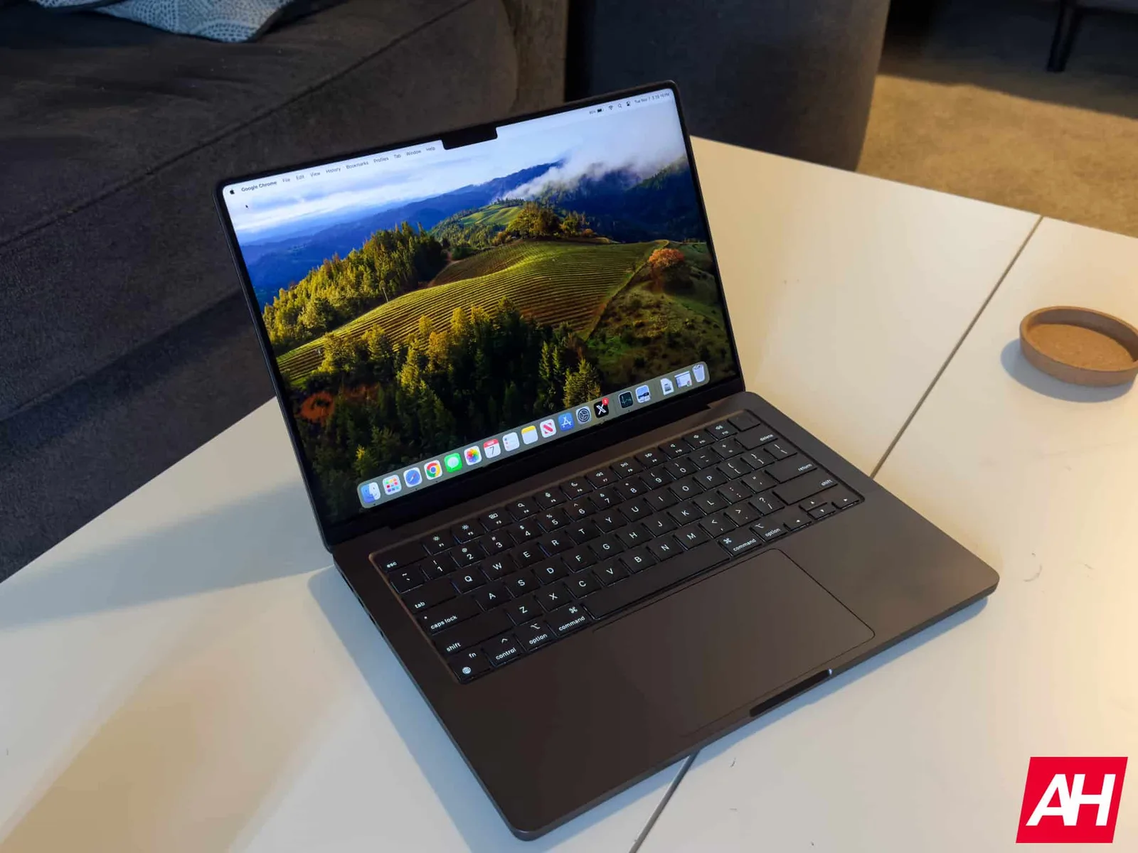 Un MacBook Pro modern pe o masă, cu un peisaj vibrant pe ecran.