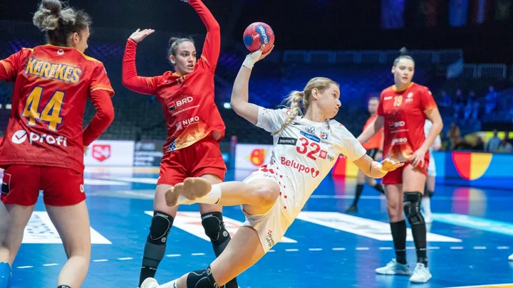 Jucătoare de handbal în acțiune pe terenul de joc.