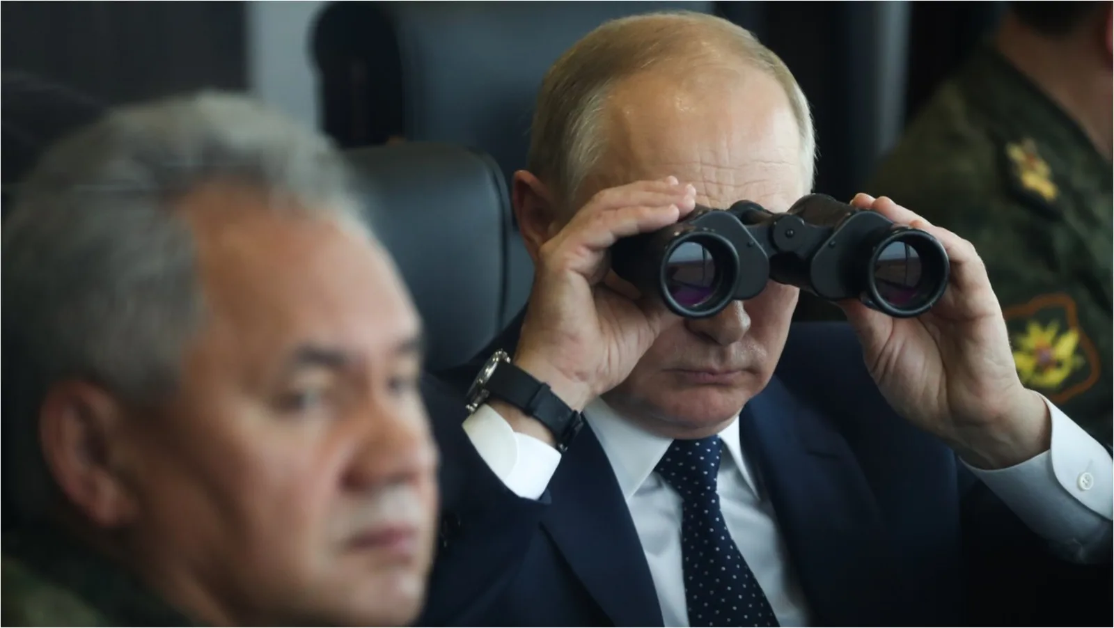Vladimir Putin observând situația cu binoclu în timpul unei întâlniri oficiale.