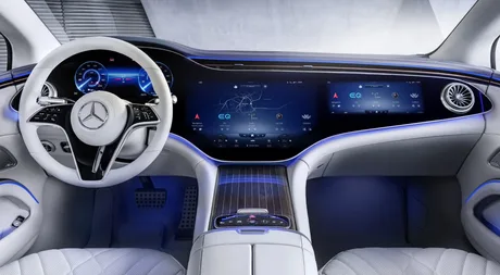 Interior modern Mercedes-Benz cu ecrane mari și comenzi fizice pe volan.