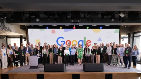 Grup de oameni la un eveniment Google, cu logo-ul vizibil.