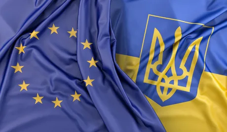 Steagurile Uniunii Europene și Ucrainei fluturând împreună.