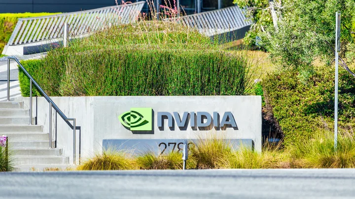 Logo-ul Nvidia într-o zonă verde, cu plante și arhitectură modernă.