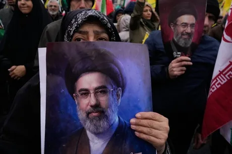 O persoană ține un portret al liderului iranian în timpul unei manifestații.