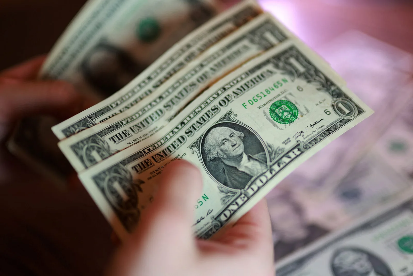 Bancnote de dolari americani în mână, simbolizând creșterea economică.