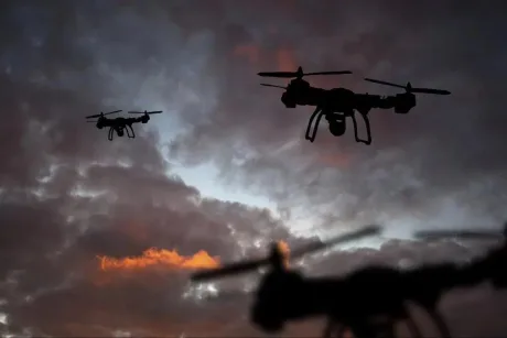 Drone zburând pe un fundal de nori întunecați la apus.