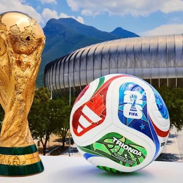 Trofeul Cupei Mondiale FIFA și o minge de fotbal pe stadion.