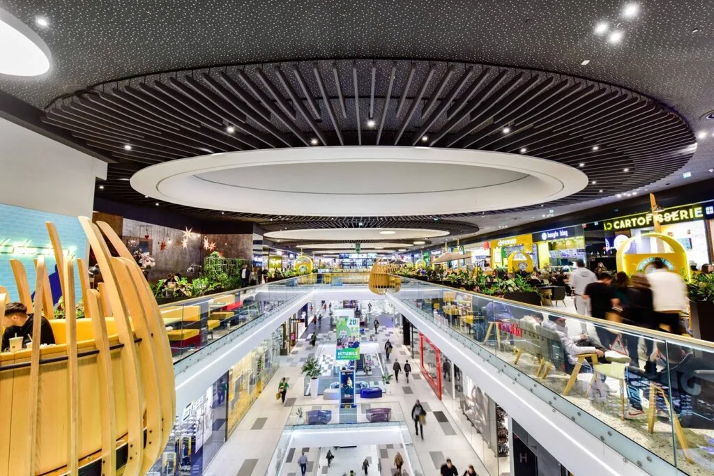 Interior modern al unui mall, cu plante decorative și zone de relaxare.