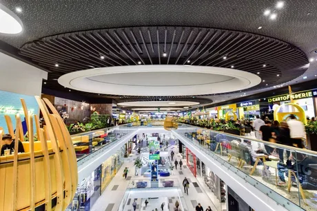 Interior modern al unui mall, cu plante decorative și zone de relaxare.
