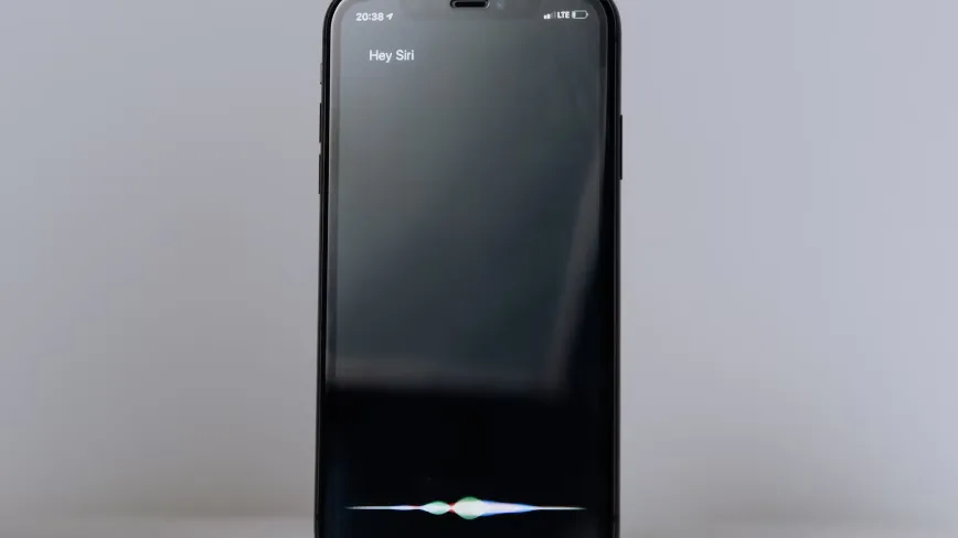 Siri pe un iPhone, pregătit pentru noi funcții AI în iOS 27.