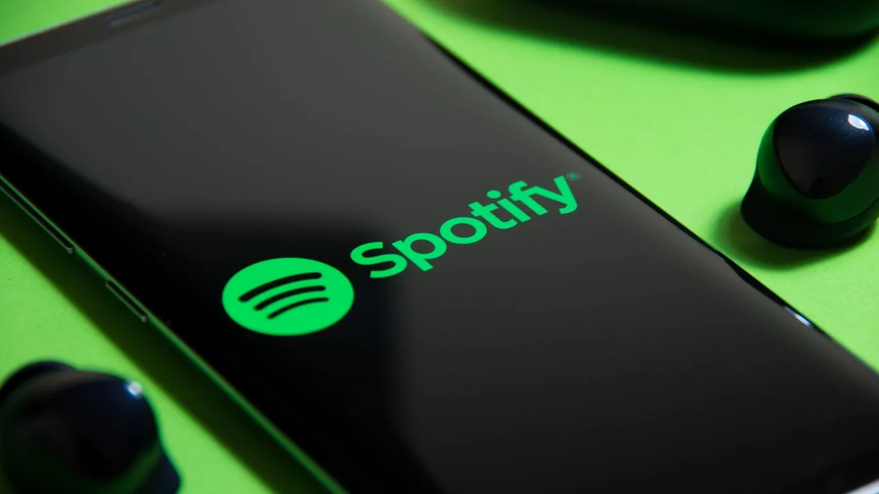 Dispozitiv mobil cu logo Spotify pe un fundal verde vibrant.