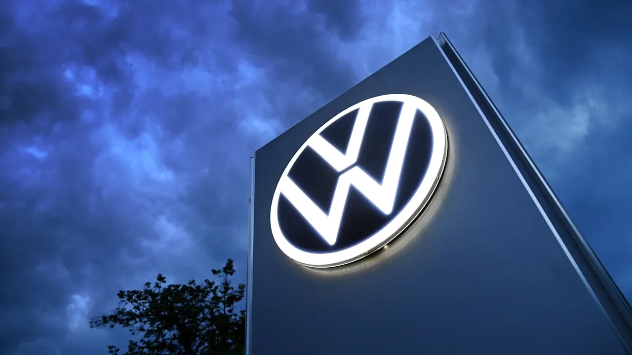Logo Volkswagen iluminat pe fundal de nori întunecați.