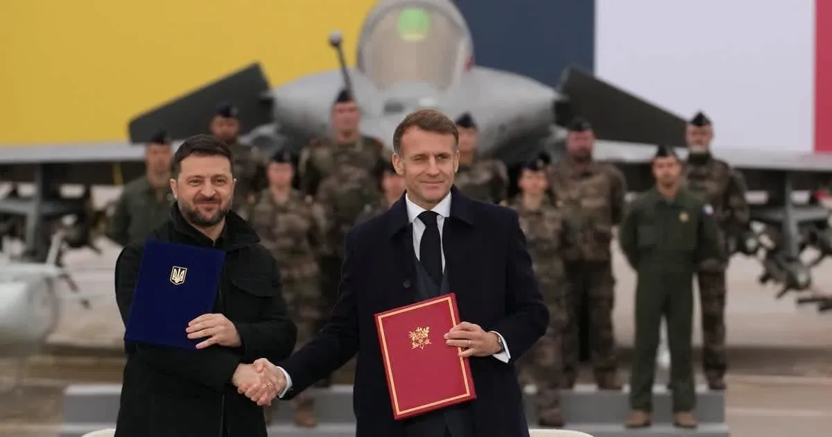 Zelenski și Macron strâng mâna după semnarea acordului.