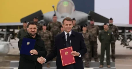 Zelenski și Macron strâng mâna după semnarea acordului.
