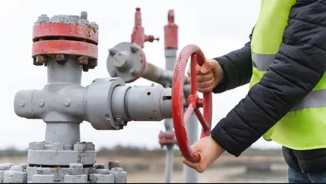 Valvă de gaz reglată de un lucrător în echipament de protecție.