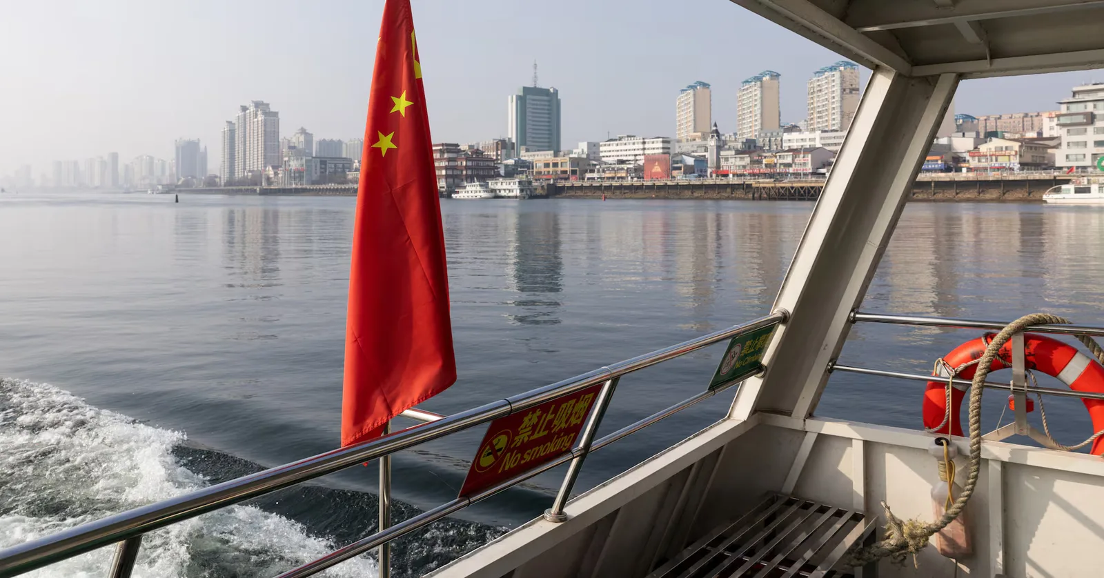Peisaj urban din China, cu clădiri moderne și apă în prim-plan.