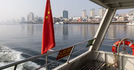Peisaj urban din China, cu clădiri moderne și apă în prim-plan.