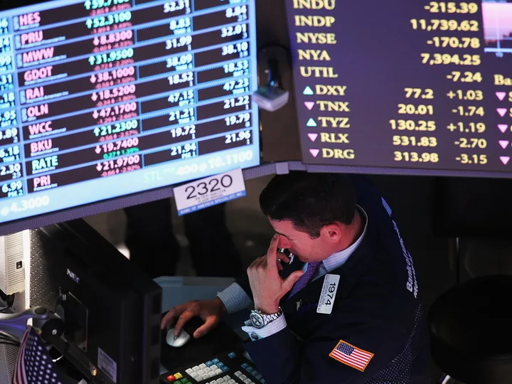 Un trader analizează datele bursiere pe un ecran plin de informații financiare.