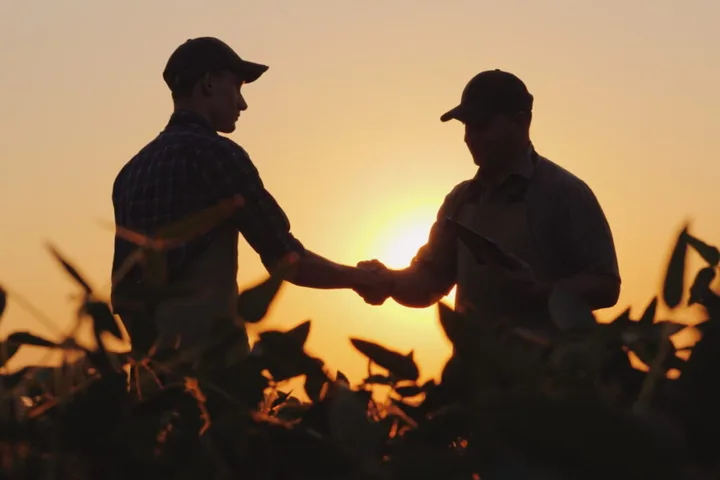 Colaborare între fermieri la apus, simbolizând sprijinul pentru dezvoltarea agriculturii.