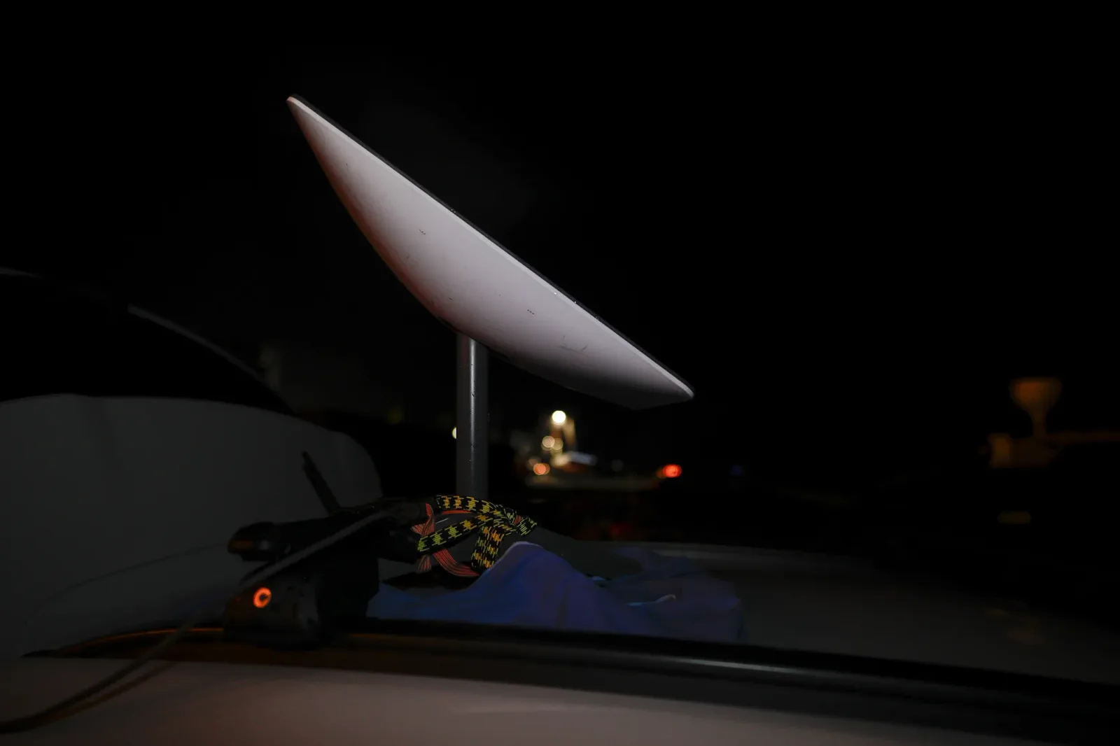 Antena Starlink montată pe un vehicul în noapte.