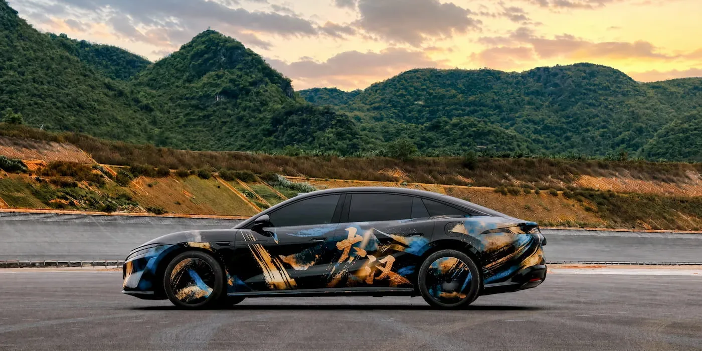Sedanul electric Da Han, cu un design futurist, pe fundal montan.