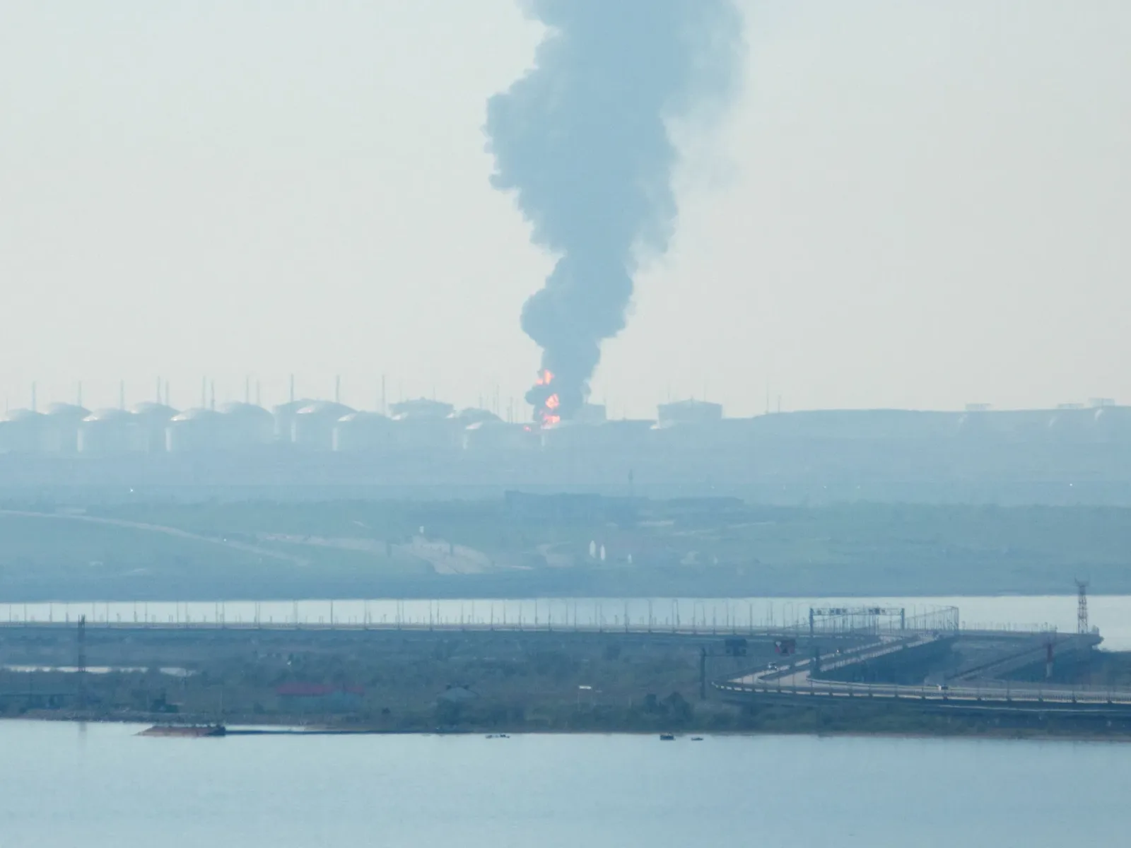 Fum gros se ridică deasupra unei instalații industriale afectate de atacuri.
