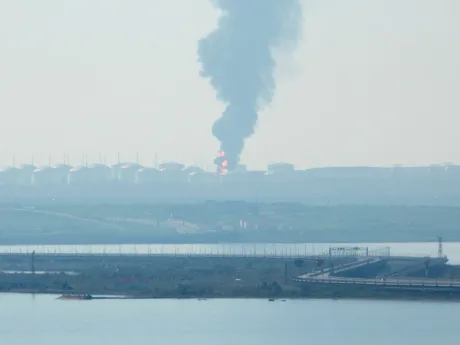Fum gros se ridică deasupra unei instalații industriale afectate de atacuri.