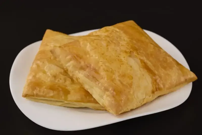 Merdenele delicioase pe un platou alb, cu o crustă aurie și crocantă.