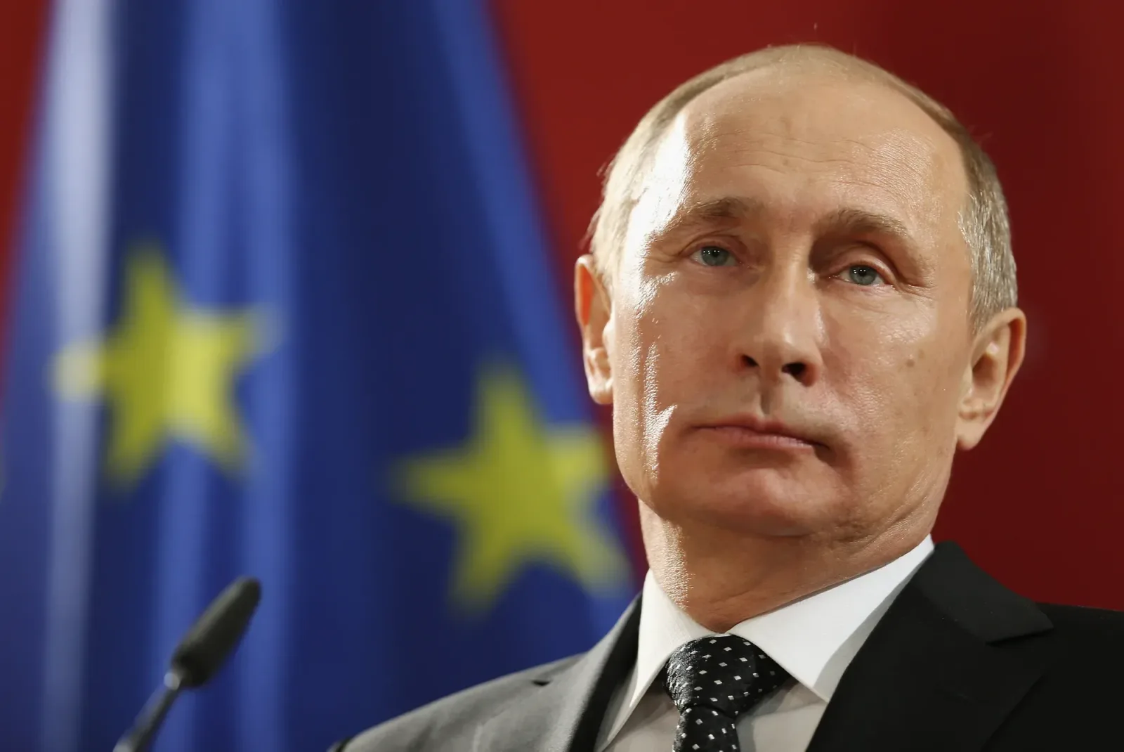 Vladimir Putin în fața steagului Uniunii Europene, reflectând asupra sancțiunilor.