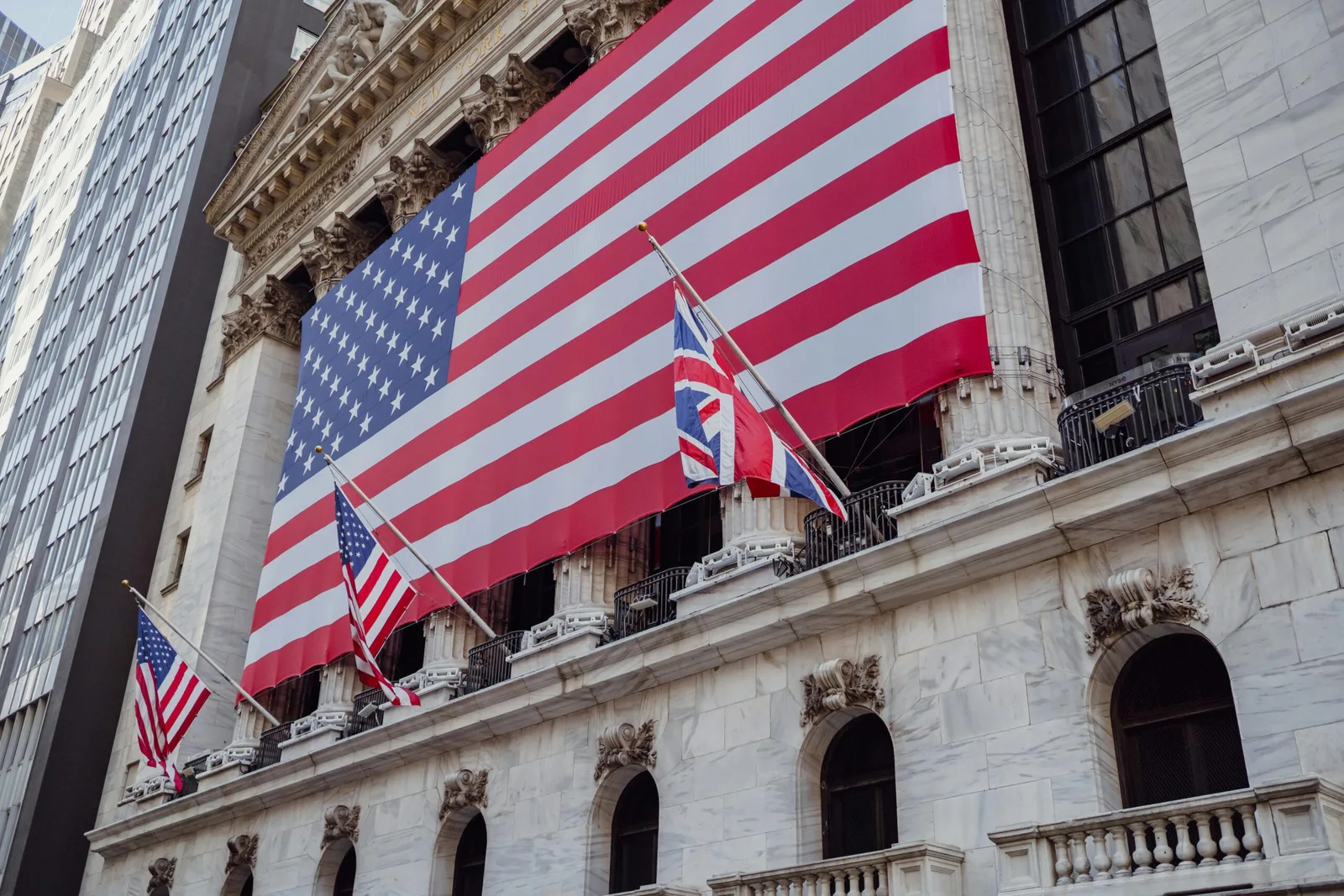Clădire guvernamentală cu steaguri americane și britanice expuse.