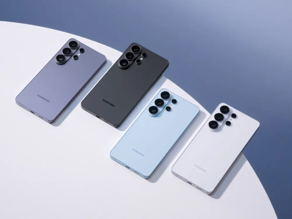 Patru telefoane Samsung de culori diferite așezate pe o masă albă.