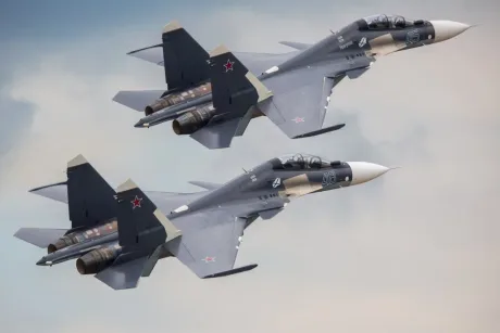 Avioane de vânătoare zburând în formație pe un fundal de cer senin.