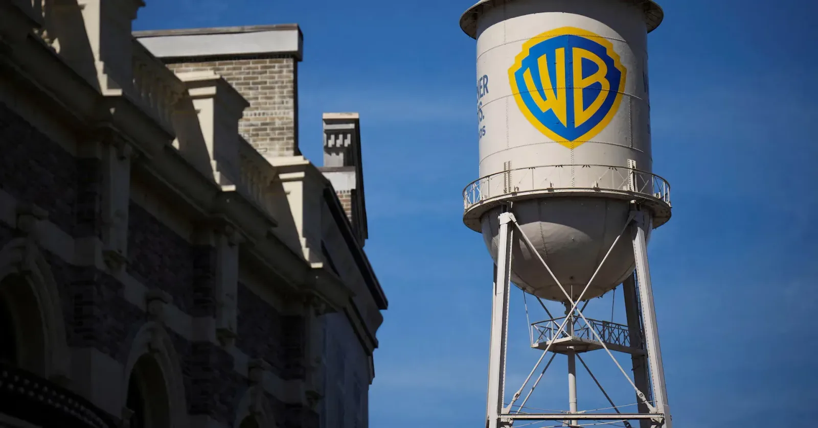 Rezervor de apă cu logo-ul Warner Bros pe fundal albastru.